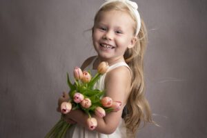 A little girl holding a bouquet of tulips.