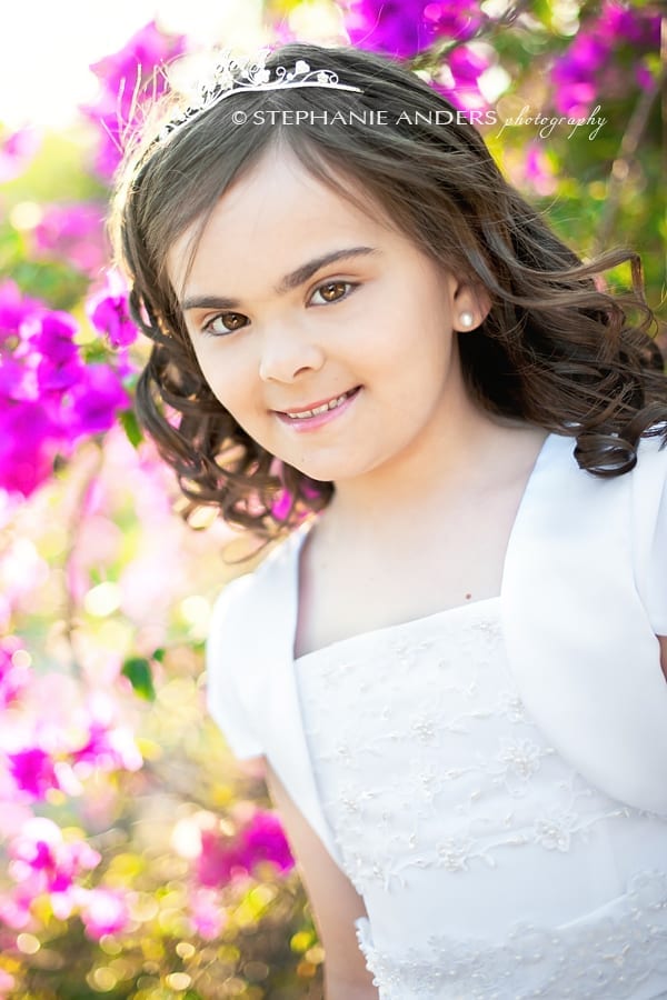 pink flowers and small girl during first communion photo shoot