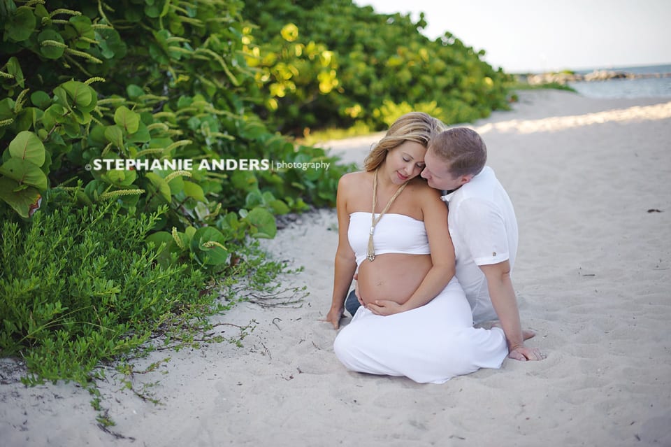 loving couple during maternity photo shoot on beach