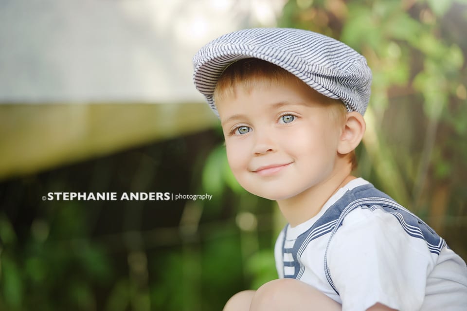 blue eyed young boy with cap smiling