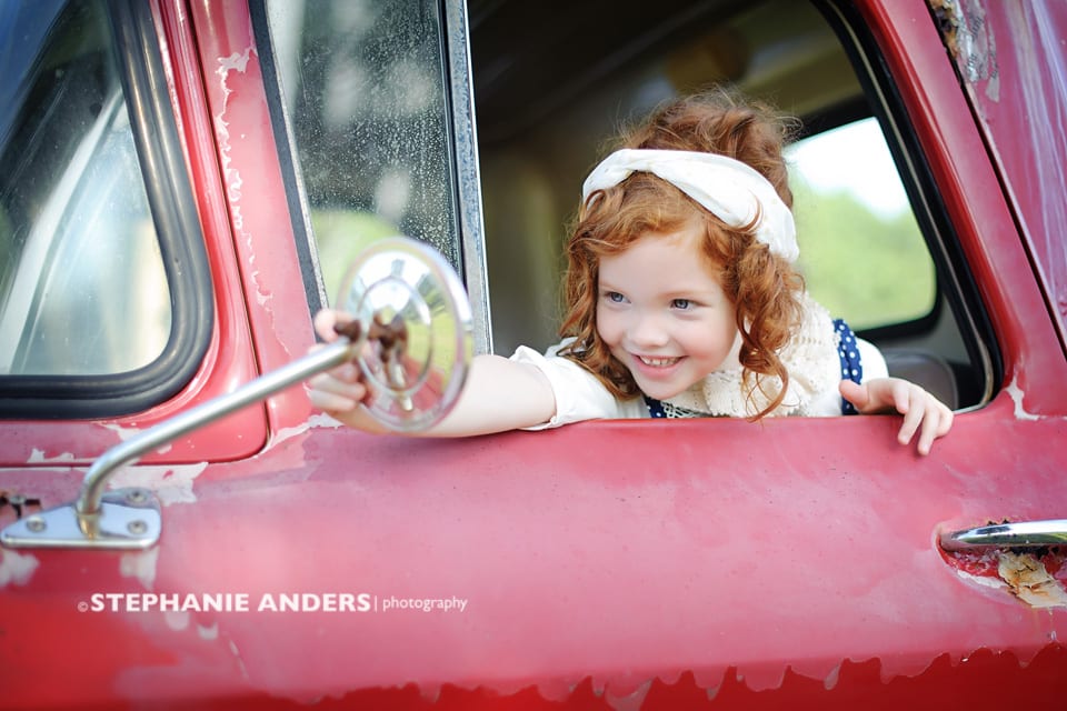 red head girl in red truck at rustic fields location in Jupiter