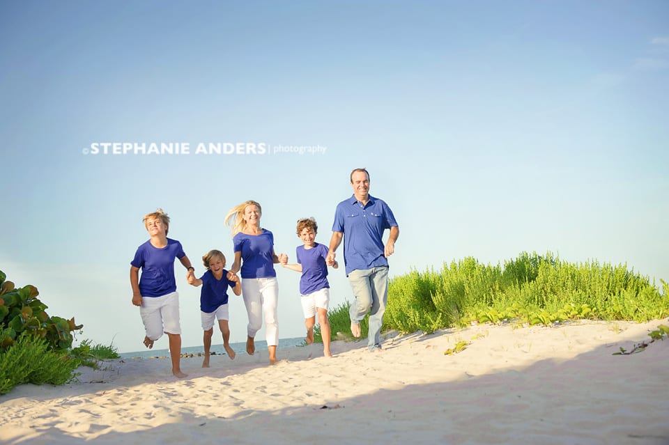 barefoot family at beach and dressed in blue shirts