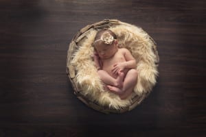 baby in driftwood basket