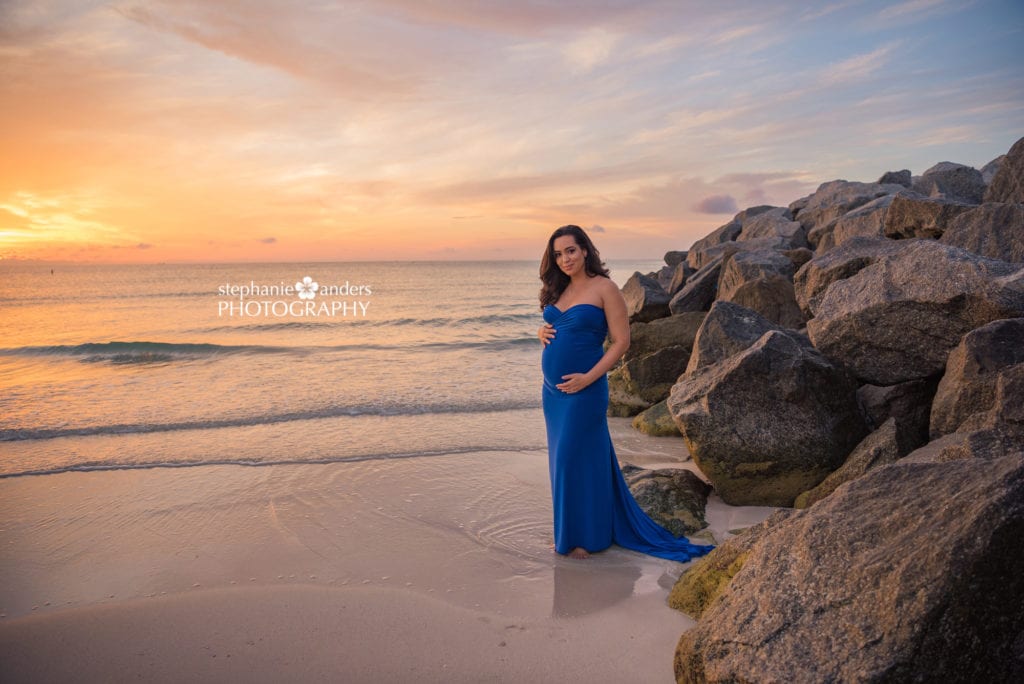 south beach pregnancy photoshoot with rock jetty and sunset sky