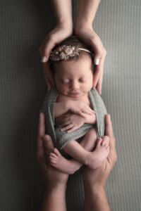newborn girl with parent hands