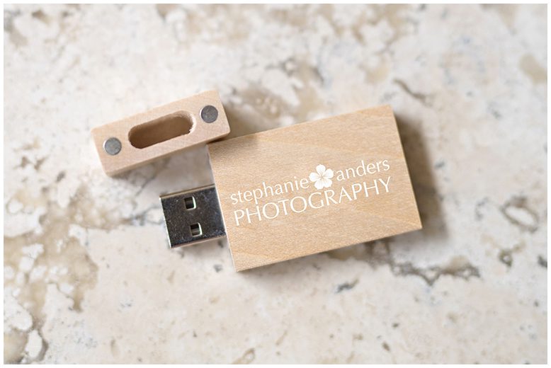 A wooden usb drive with a logo on it.
