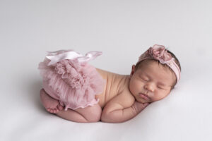 Sleeping newborn baby photographed by a Miami newborn photographer in a soft neutral studio setup.