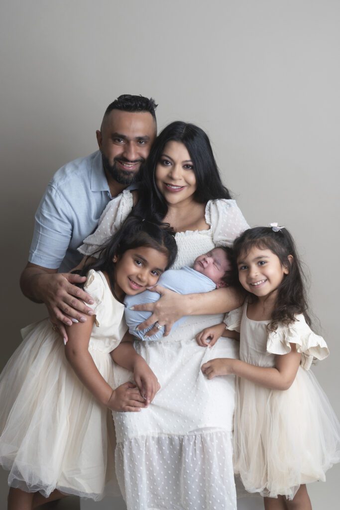 Family cuddling their newborn baby during a Miami newborn photography session.